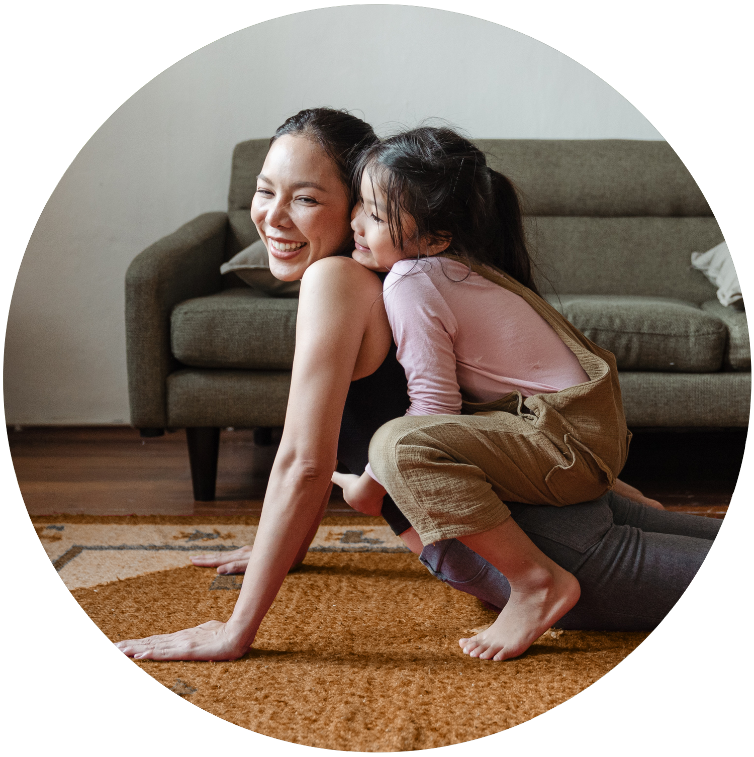 Woman doing yoga with her young daughter on her back